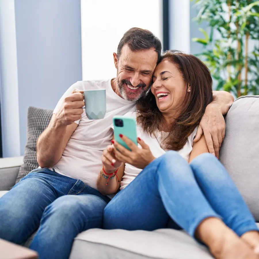 Happy couple smiling and sitting on the couch